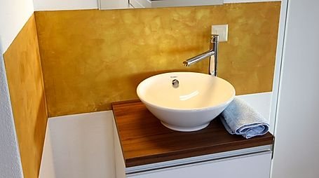 Metallic-Wand hinter einem Aufsatzlavabo
