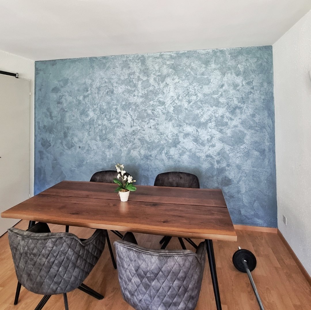 Blaue dekorative Wand hinter einem Esstisch